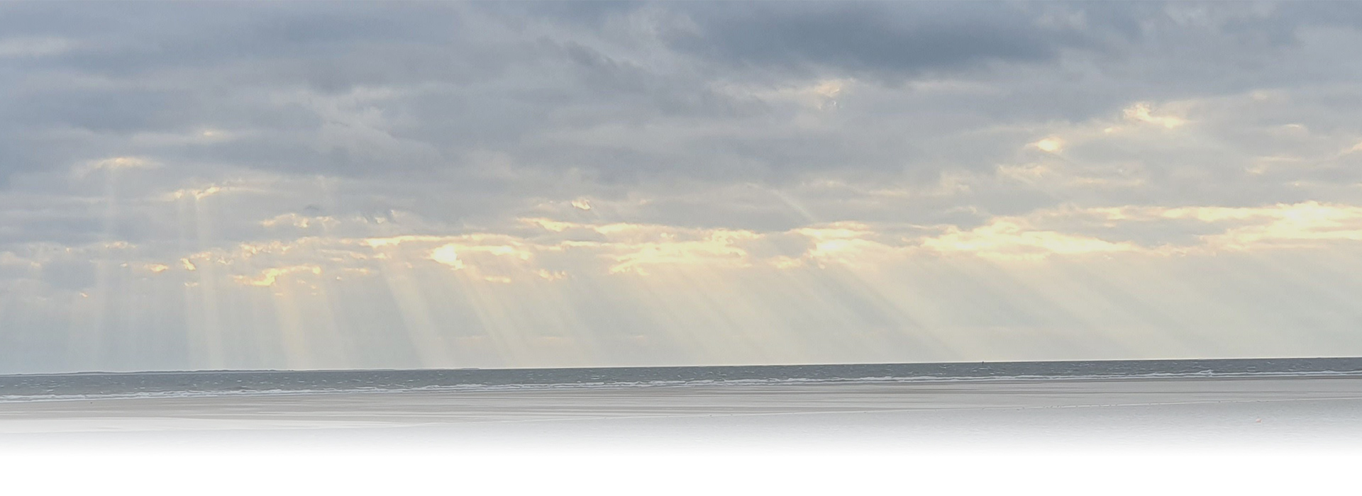 Sonnenstrahlen durch Himmel am Meer